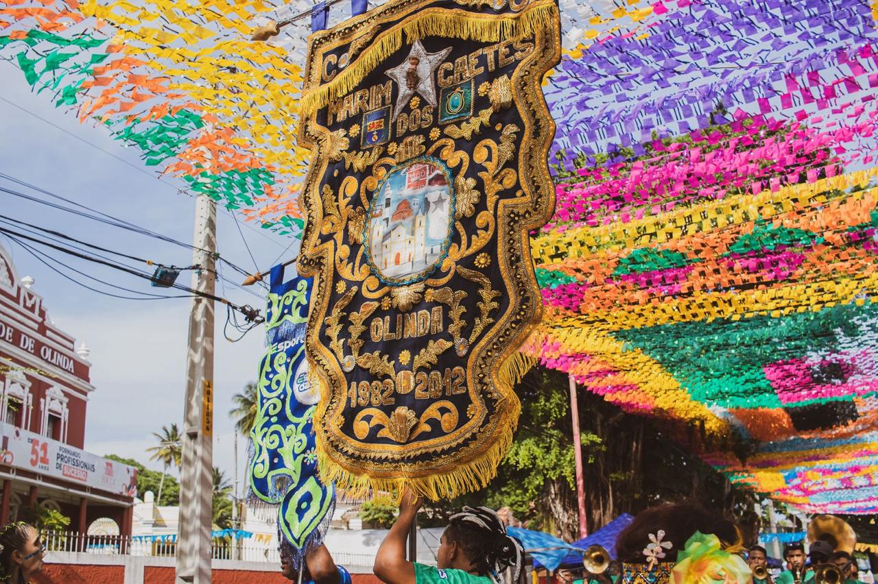 Estandarte histórico bordado da Marim dos Caetés sob decoração de bandeirolas coloridas